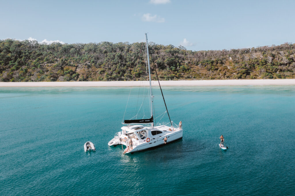 Yacht at anchor with person on paddleboard